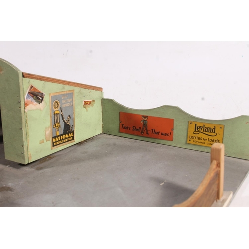 128 - Mid-20th century painted wooden model of a garage and garage forecourt, 48cm wide.