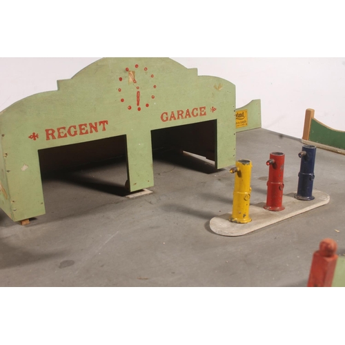 128 - Mid-20th century painted wooden model of a garage and garage forecourt, 48cm wide.