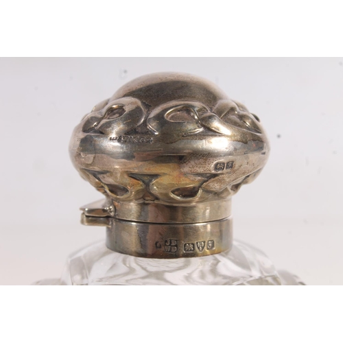 213 - Three hallmarked silver and glass table scent bottles.