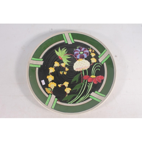 74 - Scottish Bough Pottery charger decorated with flowers, 39cm wide.