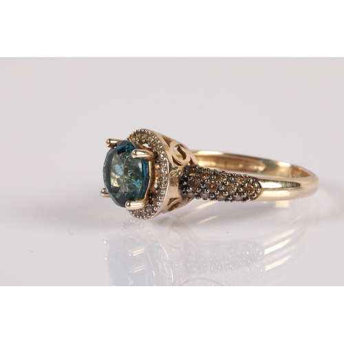 104 - 9ct gold ring set with a central blue gemstone, a halo of diamonds and champagne diamond shoulders, ... 