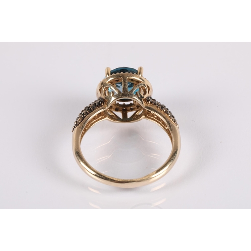 104 - 9ct gold ring set with a central blue gemstone, a halo of diamonds and champagne diamond shoulders, ... 