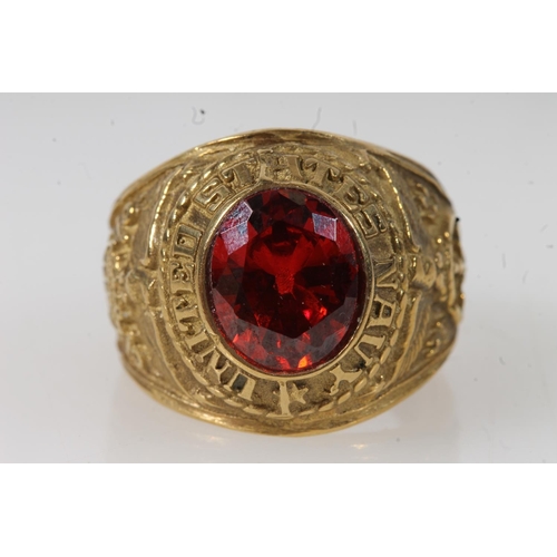 570 - Yellow metal United States Navy ring set with central red stone, stamped 10k. 