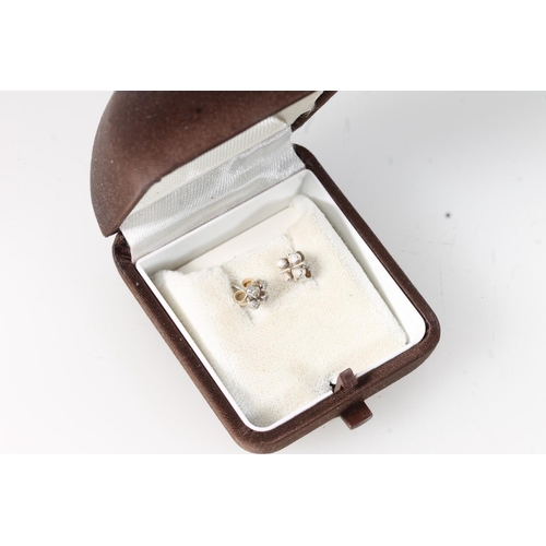 581 - A pair of white metal earrings set with four small stones.