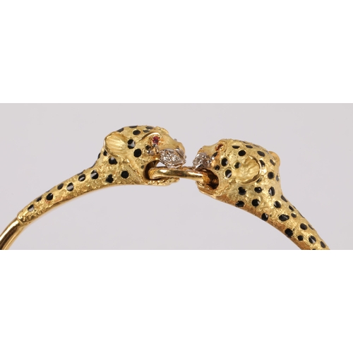 51 - 18k gold bangle in the form of two leopards grasping a ring, set with diamonds, rubies for eyes and ... 