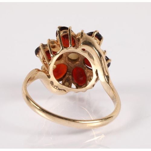 58 - 9ct gold ring set with garnets and simulated pearls in a flower design, ring size P, 3.9g