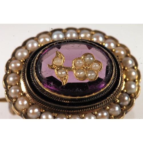 671 - Antique gold amethyst and seed pearl set brooch, the central stone set with floral pearl.