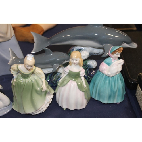 33 - Nao figurine of a washerwoman, a Lladro dolphin model and Royal Doulton figures.