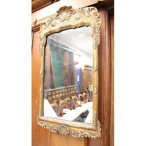 769 - Gilt framed wall mirror with conch shell decoration, 71cm tall.