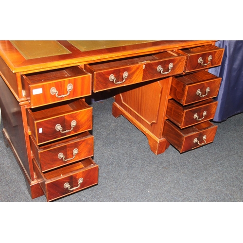 768 - Mahogany twin pedestal nine drawer desk with green leather skiver.