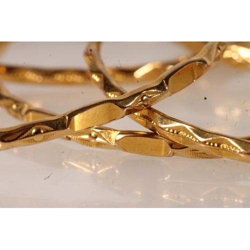 141 - Set of twelve yellow metal bangles, of plain form with patterned edges.