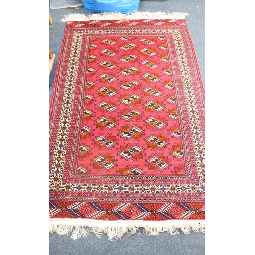 645 - Red ground geometric patterned rug with multi border and fringed rug.