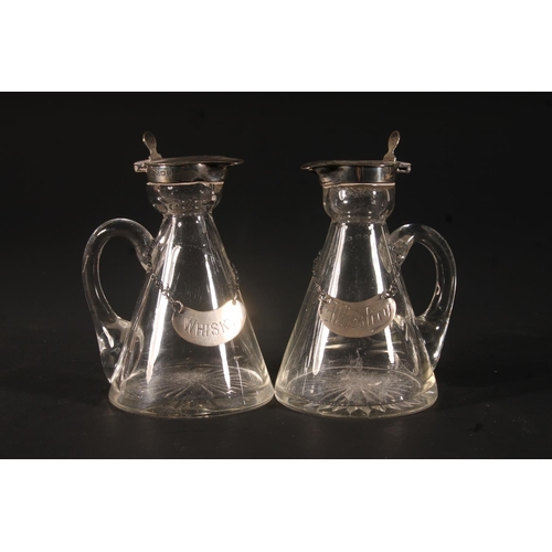 32 - Pair of Edwardian whisky noggins, the hinged silver covers over a conical glass bottle with star cut... 