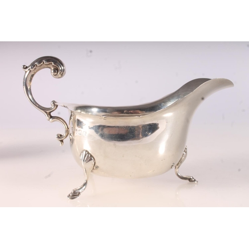 40 - Two Geo. V silver cream jugs, with scalloped edges and acanthus scroll handles on three shell and pa... 