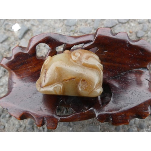 315 - Chinese celadon jade carving of a recumbent kylin, Qing Dynasty, on a padouk stand, 9cm, and another... 