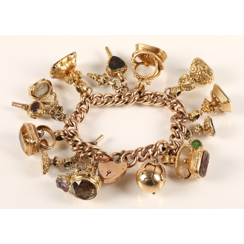 71 - Gold hollow curb link charm bracelet with seventeen assorted charms to include 9ct gold masonic ball... 