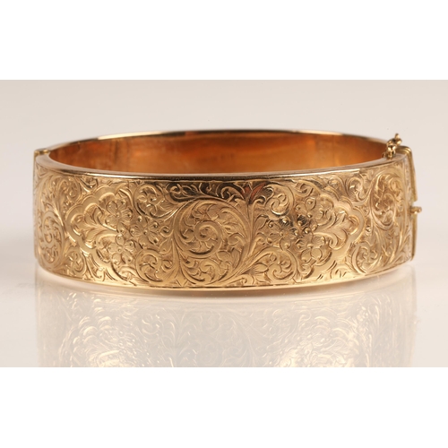 73 - Ladies 9ct yellow gold broad hinged bangle with engraved detail, weight 23.8g