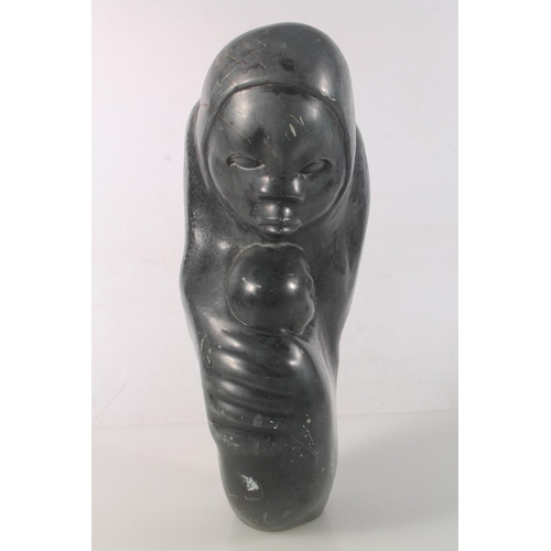 23 - Zimbabwean carved serpentine figure of a mother and child, signed to base Amonmwa, 31cm high.