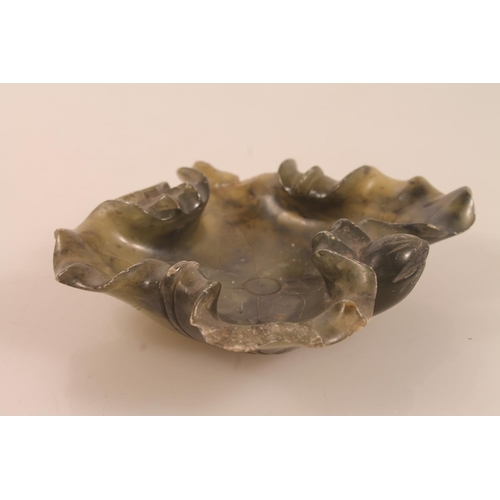 40 - Chinese carved green soapstone lily pad dish, 11cm high and a carved green hardstone fruit.
