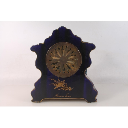 51 - French porcelain mantel clock with hand-painted classical scene, signed Petit, the dial with garland... 