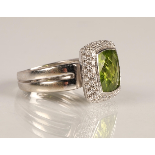 65 - Ladies peridot and diamond ring, central square cut peridot surrounded by three rows of small diamon... 