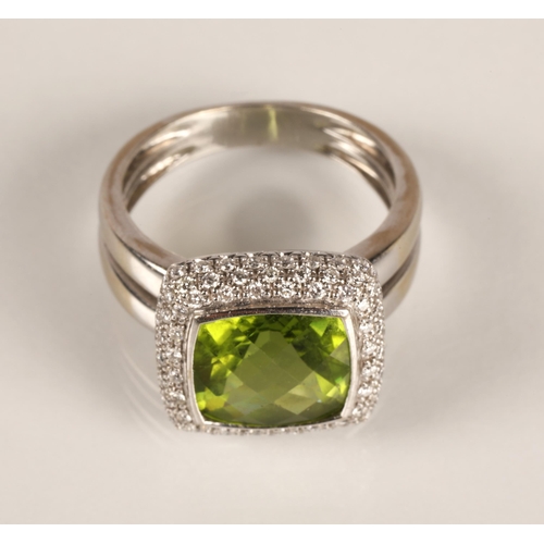 65 - Ladies peridot and diamond ring, central square cut peridot surrounded by three rows of small diamon... 