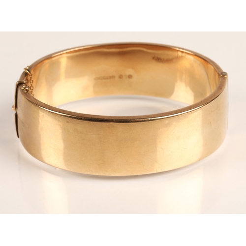 73 - Ladies 9ct yellow gold broad hinged bangle with engraved detail, weight 23.8g