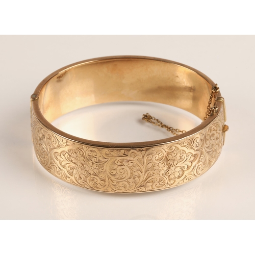 73 - Ladies 9ct yellow gold broad hinged bangle with engraved detail, weight 23.8g