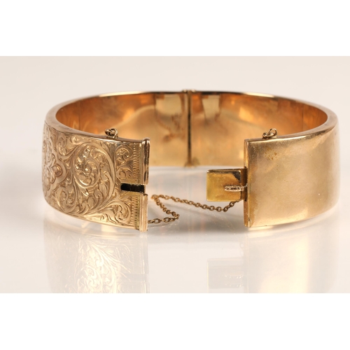 73 - Ladies 9ct yellow gold broad hinged bangle with engraved detail, weight 23.8g