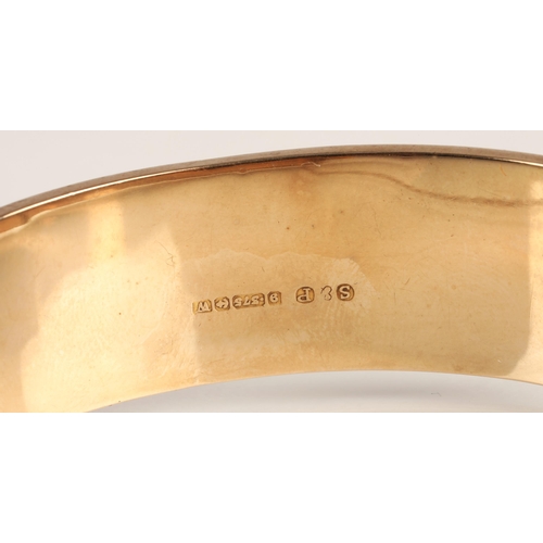 73 - Ladies 9ct yellow gold broad hinged bangle with engraved detail, weight 23.8g