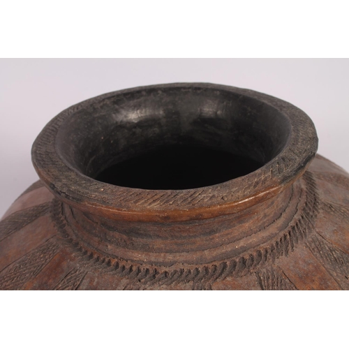 311 - An Abuja pottery water or grain bowl, the unglazed brown clay vessel of round form, the body decorat... 