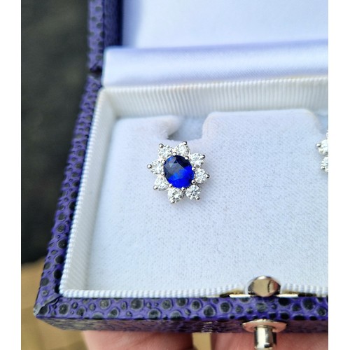 64 - Pair of ladies 18ct white gold sapphire and diamond earrings, central sapphire surrounded by eight s... 