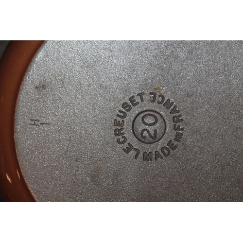 31 - Le Creuset cast iron pan, and two other Le Creuset pans on tiered iron stand.