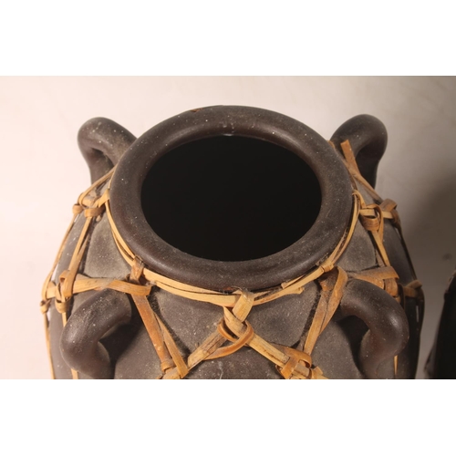 50 - Tribal style pair of pottery grain urns, and a similar vase.