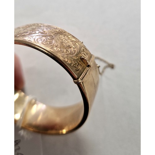 73 - Ladies 9ct yellow gold broad hinged bangle with engraved detail, weight 23.8g