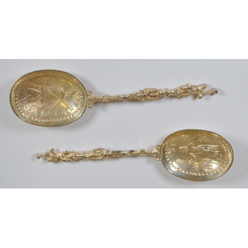 13 - Two Dutch silver spoons, c. late 19th century, with figure surmounts, embossed windmills and milkmai... 