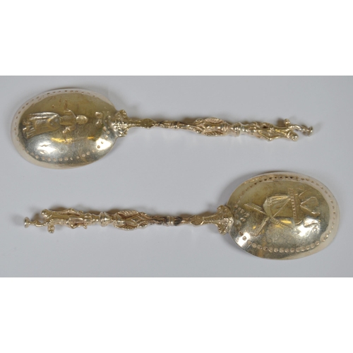 13 - Two Dutch silver spoons, c. late 19th century, with figure surmounts, embossed windmills and milkmai... 