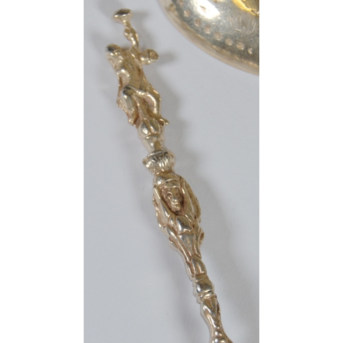 13 - Two Dutch silver spoons, c. late 19th century, with figure surmounts, embossed windmills and milkmai... 
