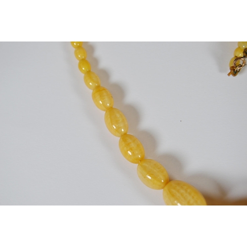 65 - String of Baltic translucent amber beads, c. early 20th century, comprising sixty-two graduated oval... 