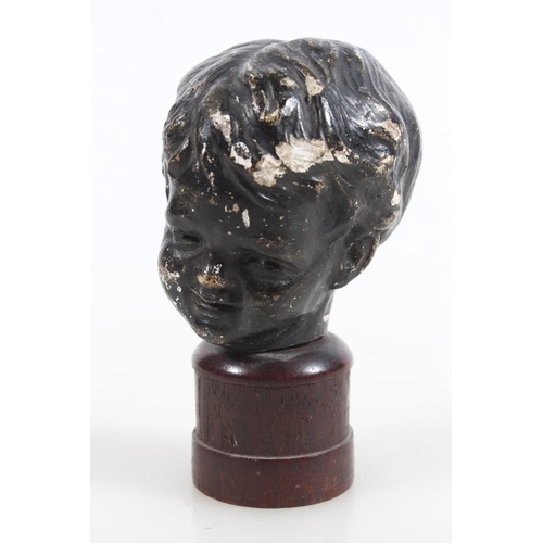 48 - Antique bronze effect on plaster statue bust of a young boy, raised on wooden base, 10.5cm tall.