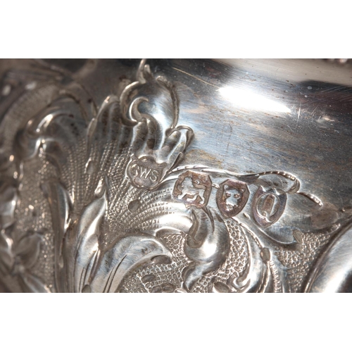 19 - Victorian silver teapot with heavily foliate decorated body and ebonised handle raised on ball suppo... 