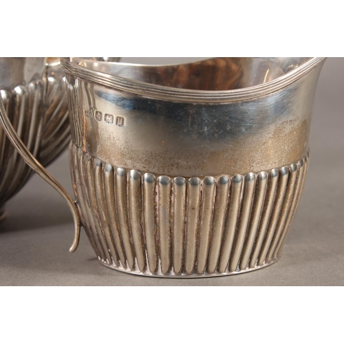 45 - Harlequin three piece silver teaset of half gadrooned form, the teapot by William Hutton & Sons ... 