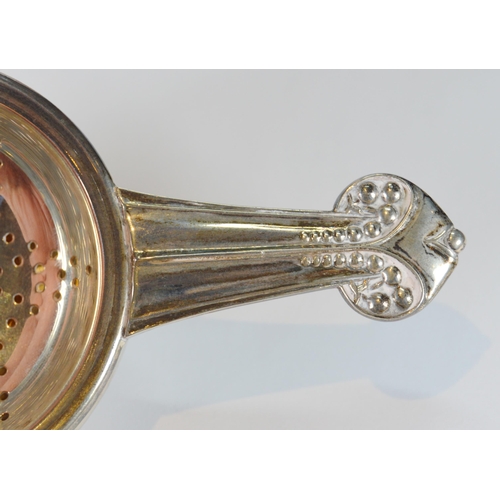 24 - Silver tea strainer, the stem handle of Secessionist theme, with bowl, by Louis Simpson Ltd., London... 
