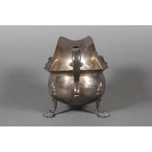53 - Silver sauce boat with wavy edged rim raised on paw supports with scrolling handle, Walker & Hal... 