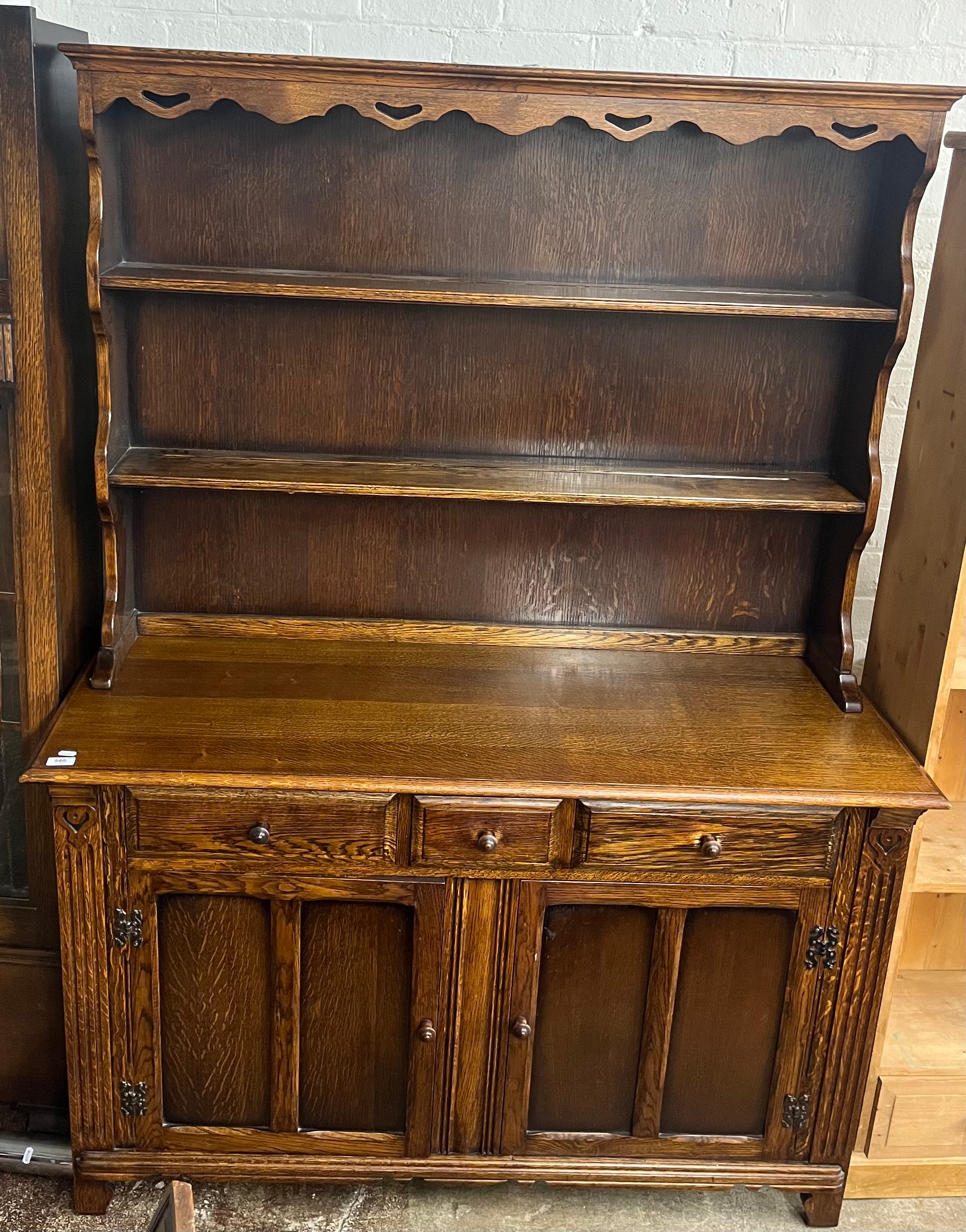 Oak dresser, the plate rack with carved frieze over three drawers and ...