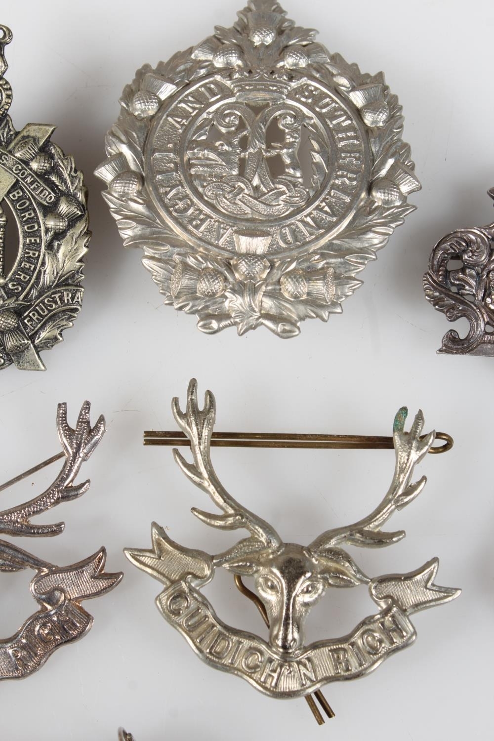 Group of military cap badges, etc and compass and whistle.