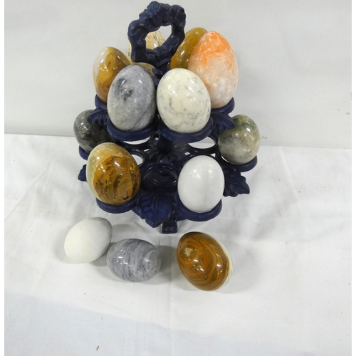 87 - Collection of stone eggs displayed on a rack.