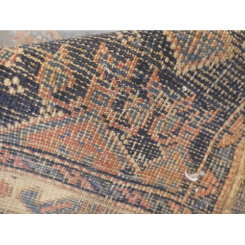 186 - Persian hand-knotted tribal rug and a Persian Sarouk rug (both have tears and wear).&nbsp; (2)