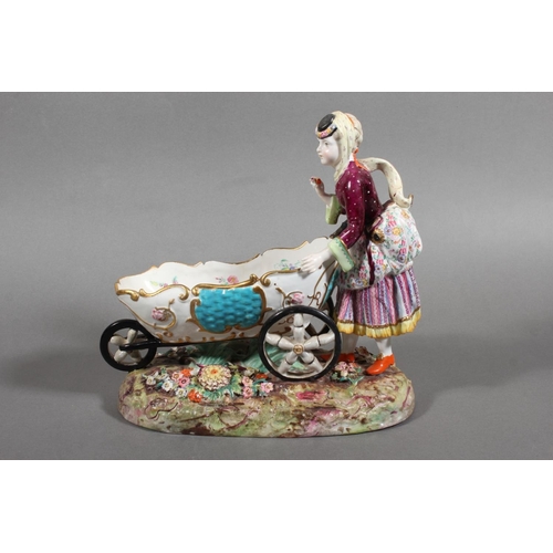 213 - Continental novelty porcelain cream boat in the form of a female flower seller pushing a three wheel... 