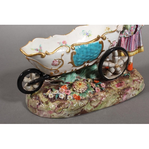 213 - Continental novelty porcelain cream boat in the form of a female flower seller pushing a three wheel... 